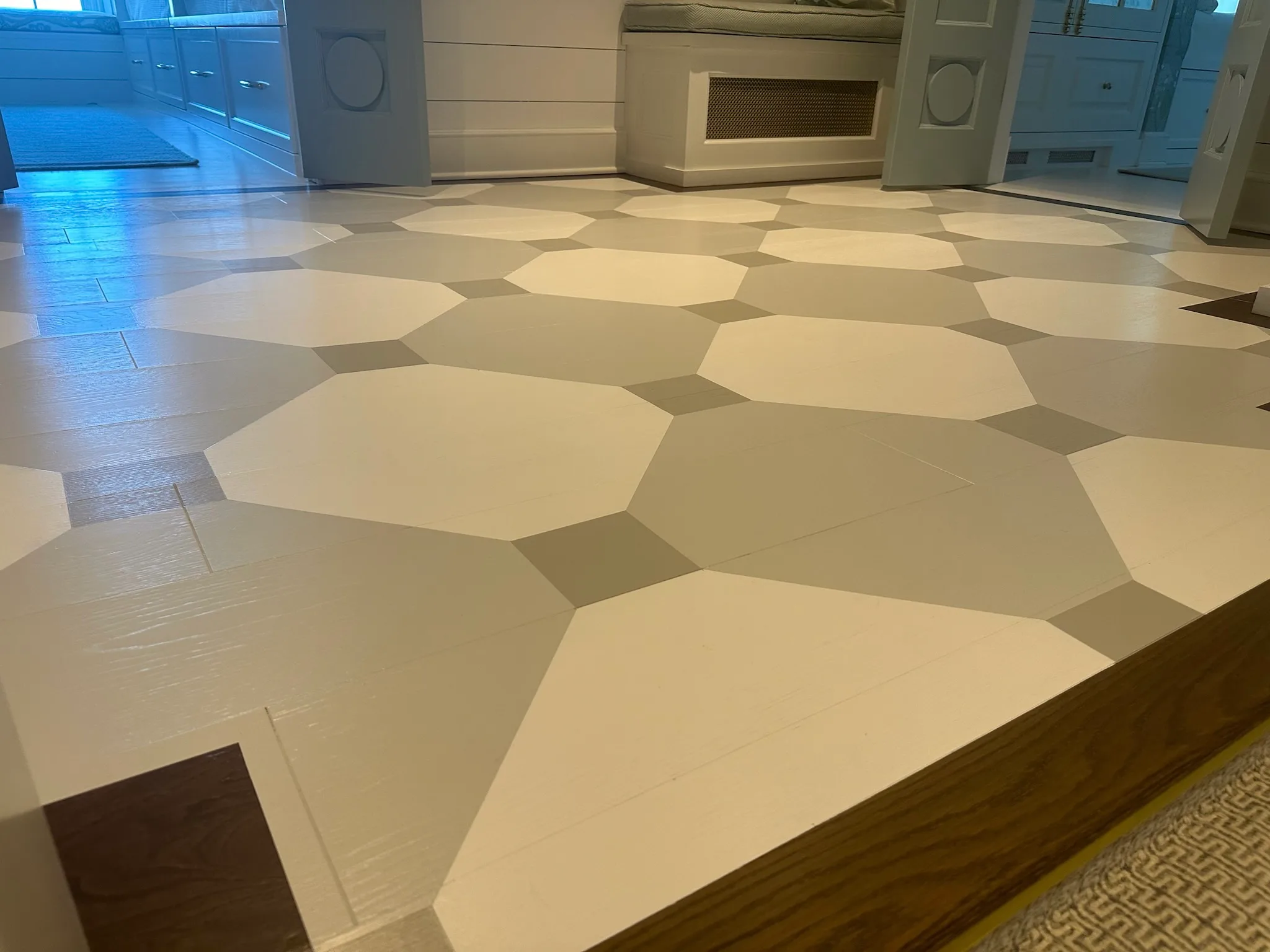 Custom white and beige patterned wood flooring in a modern kitchen, showcasing a unique and stylish design for contemporary interiors.